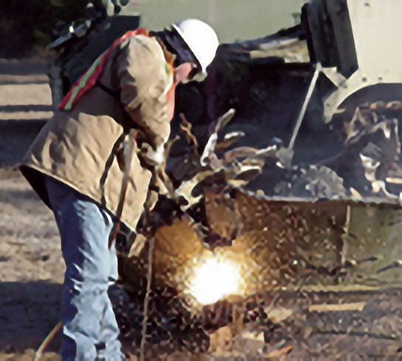 Photo of employee cutting tank metal